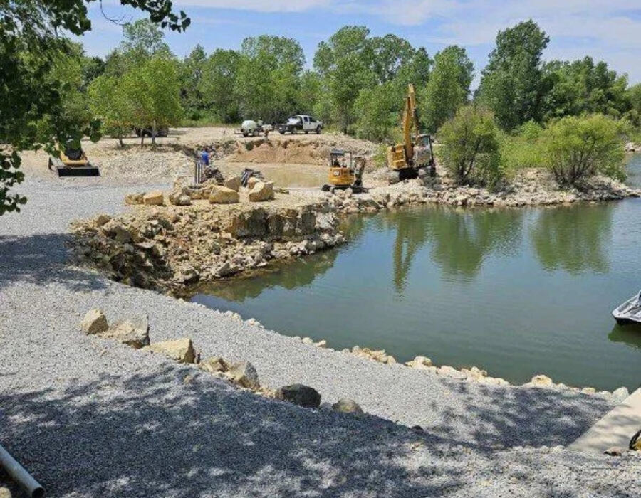 Excavator performing pond and shoreline excavation work